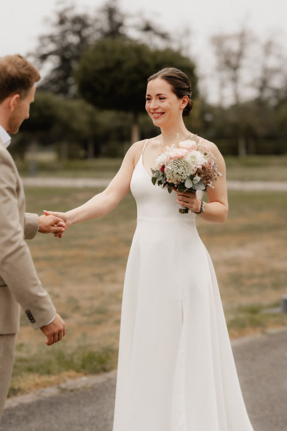 A couple shares a joyful moment during their first look on their wedding day.