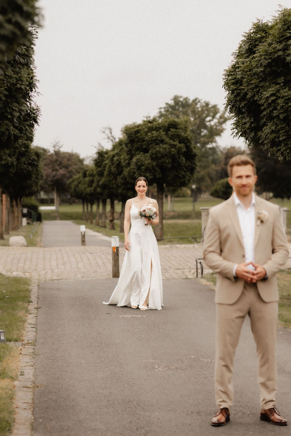 A series of wedding photos showing a couple on a tree-lined path with the bride in white and groom in tan suit.