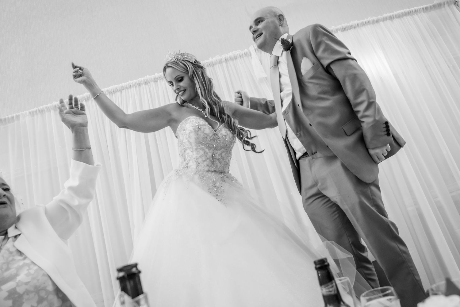 Fun wedding reception photograph taken by Michael Pardoe. Couple dancing on a table at their wedding at Lytham St Annes