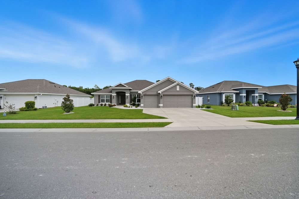 A panoramic view of suburban houses and streets in a residential neighborhood under blue skies.