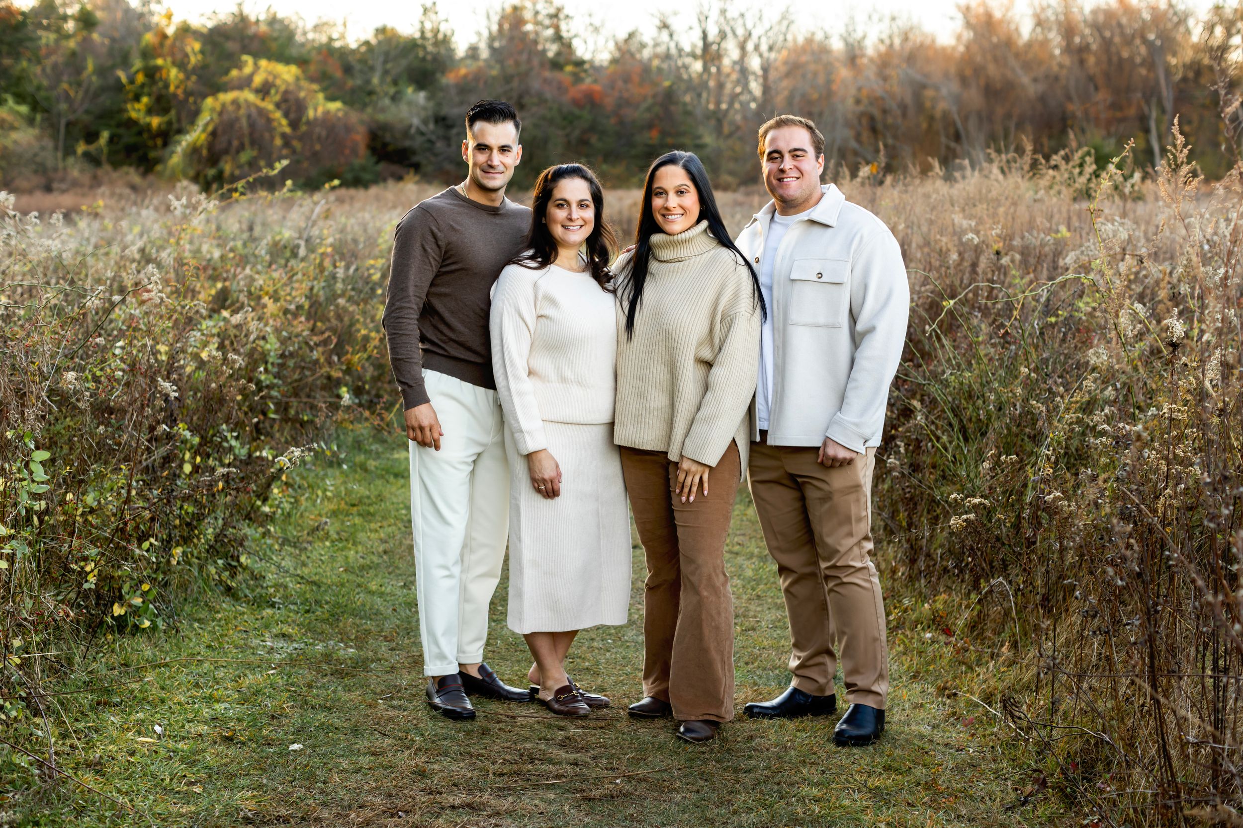 A collection of outdoor fall family portraits taken in a golden field during sunset.
