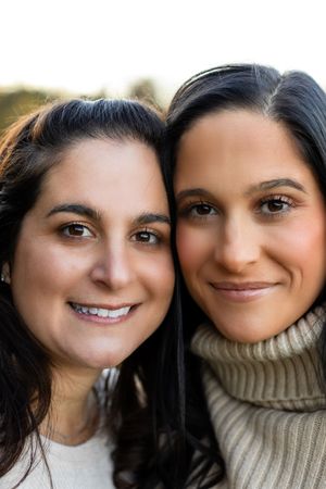 Two people pose together for a series of close-up selfies showing their smiling expressions and friendship.