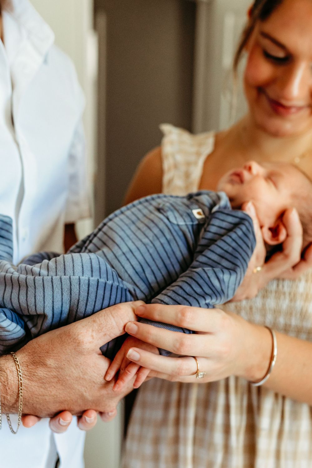 A series of hands holding and comforting each other in a tender moment against a light background.