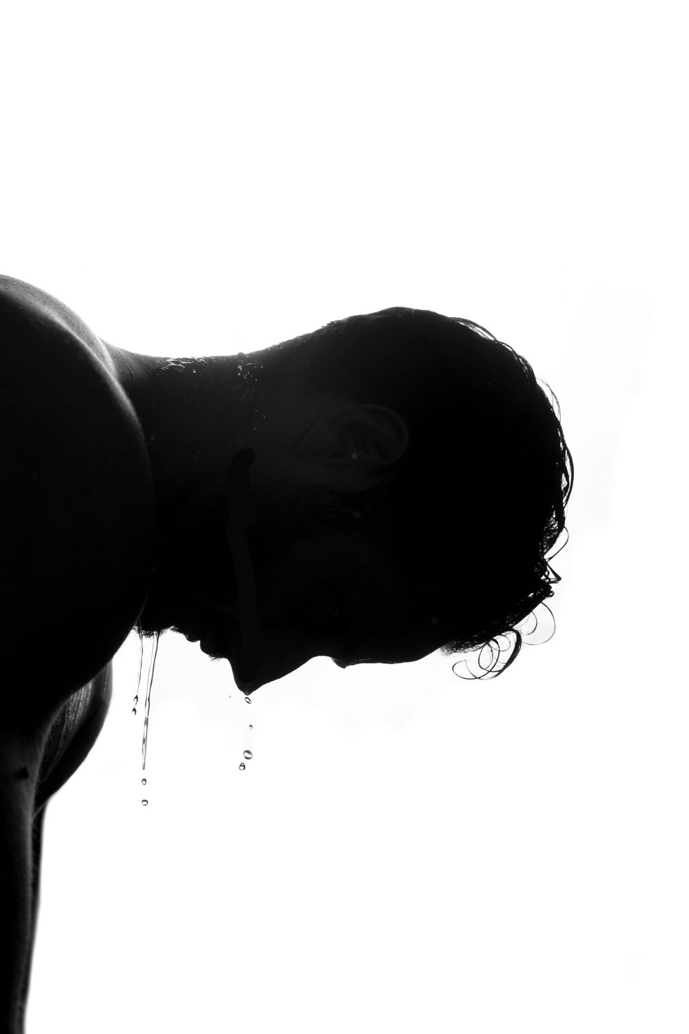 Silhouette portrait of a man in profile against a bright white background; minimalist athletic branding and artistic fitness photography.