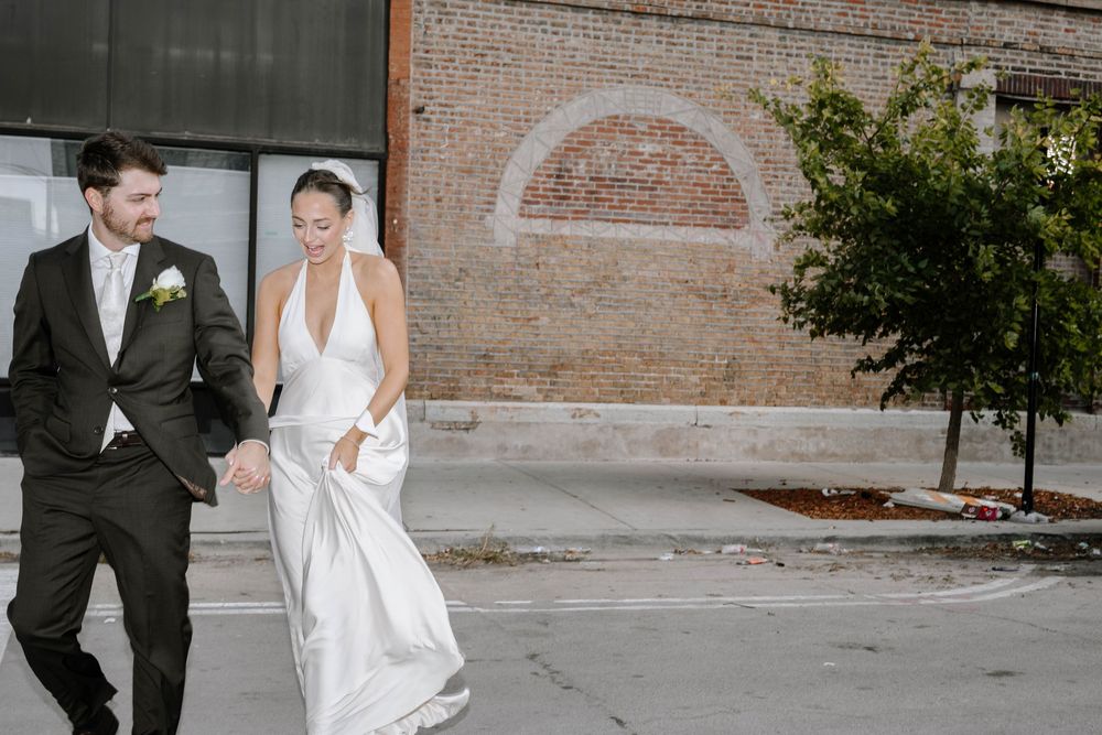 Bride and groom share a romantic moment together on their wedding day outside a rustic brick building.
