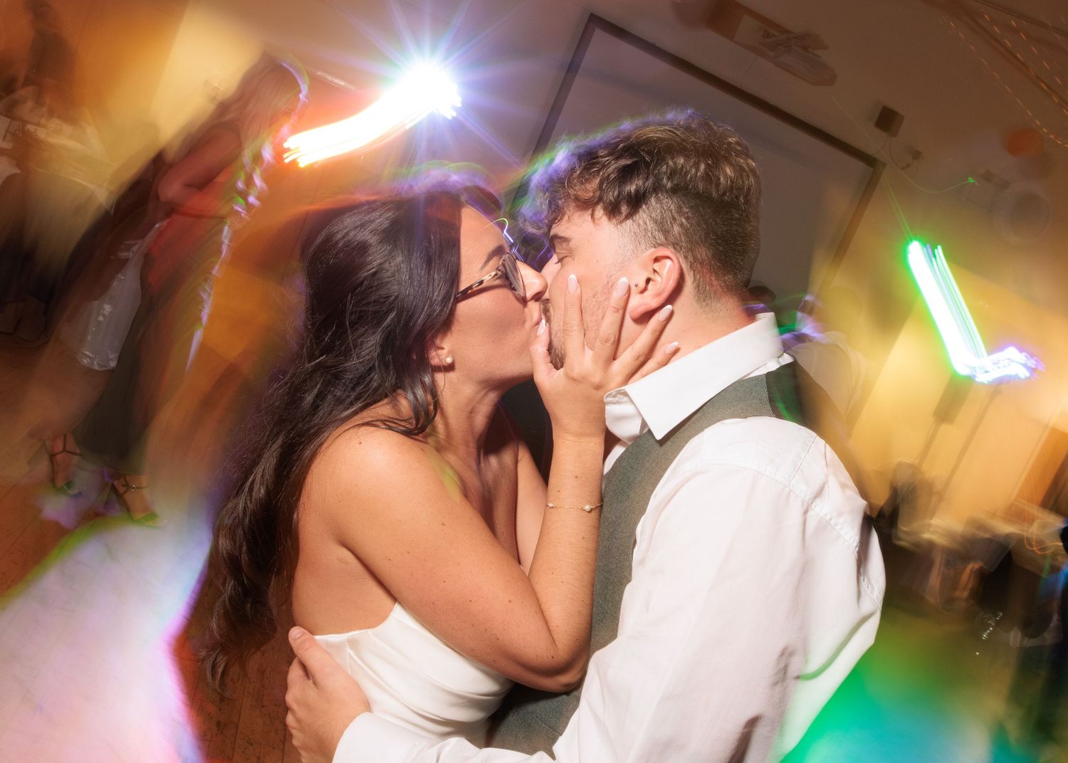 Couples dancing together during a romantic moment at an evening wedding reception.