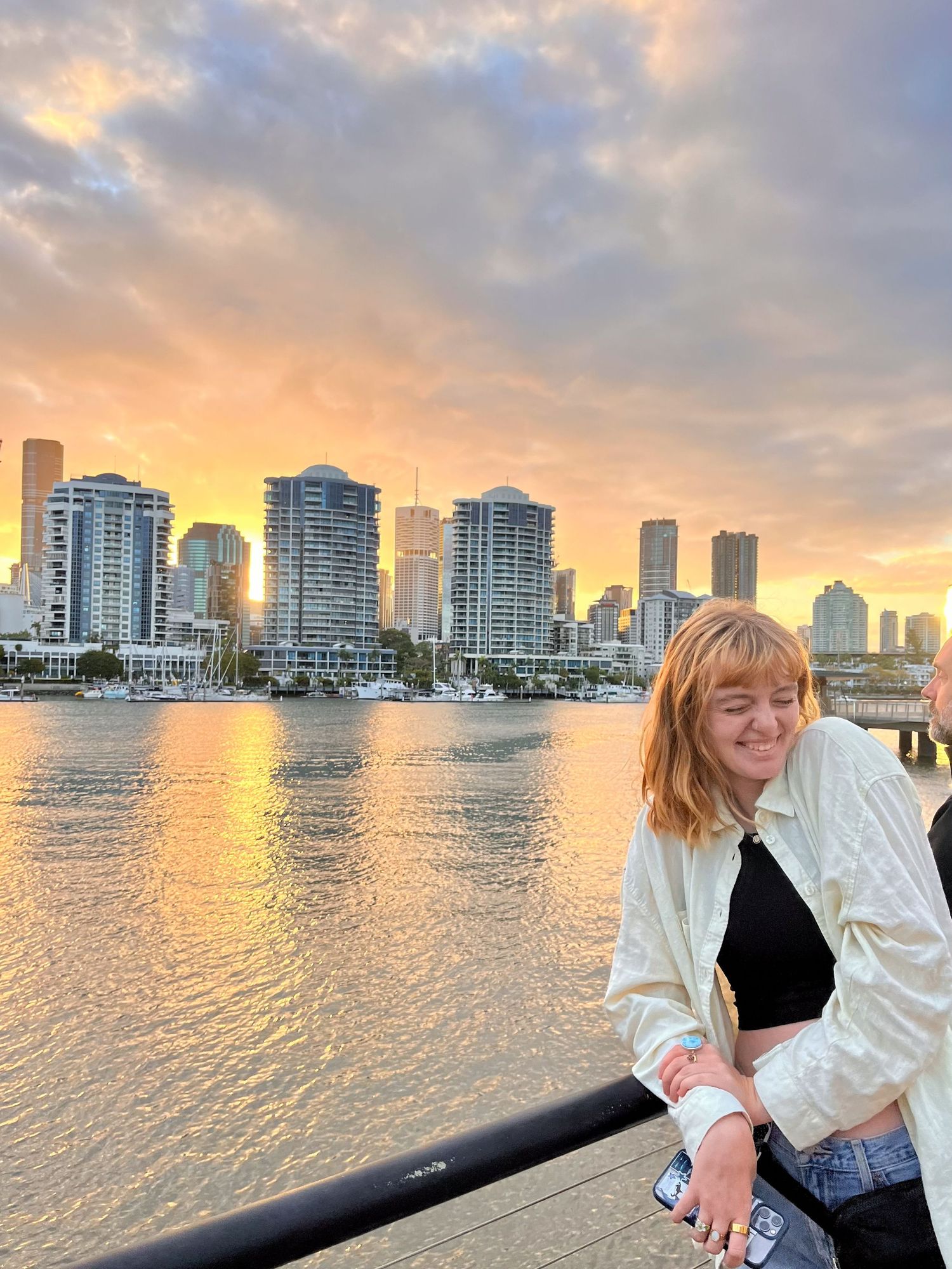 Sunset skyline view of Miami Beach with modern high-rise buildings reflecting golden light on calm waterfront.