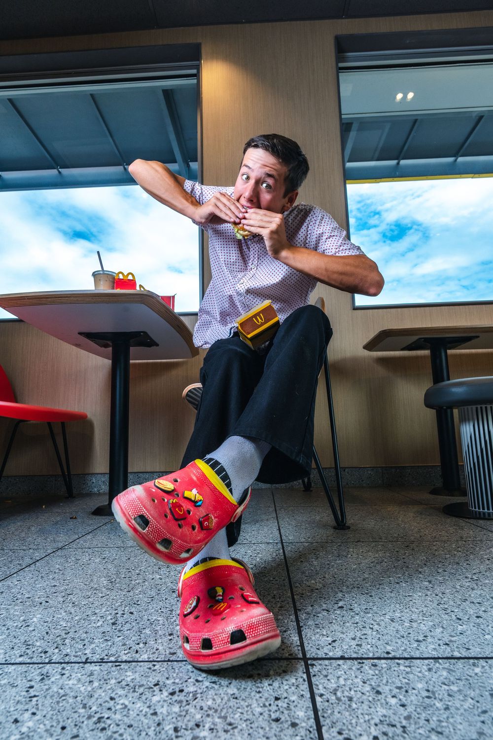 A sequence showing red Crocs footwear being used to perform a silly dance move on a speckled floor.