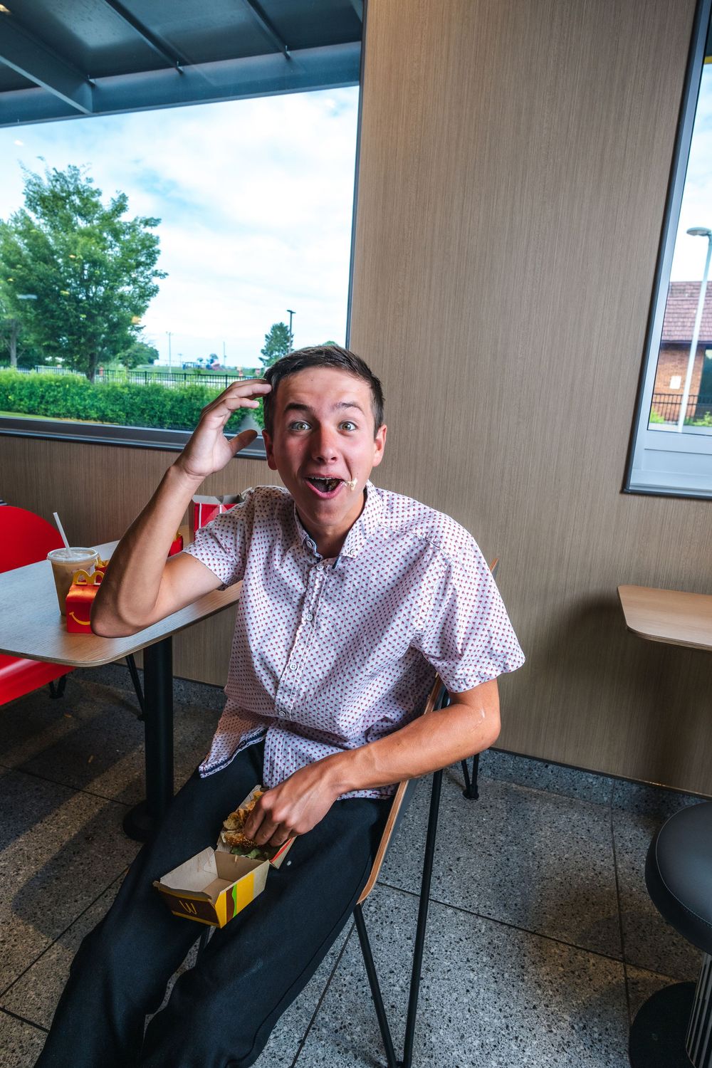 A sequence of expressive poses in a casual dining area with large windows and natural lighting.