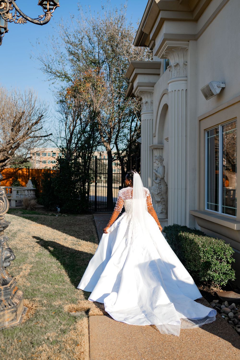 A flowing white wedding gown is photographed in multiple angles outside a classic building with white columns.