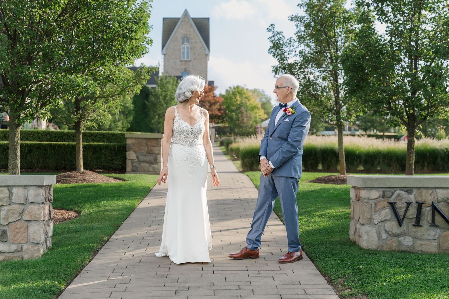 Bride and grooms first look on the stone path surrounded by greenery at Vineland Estates Winery.