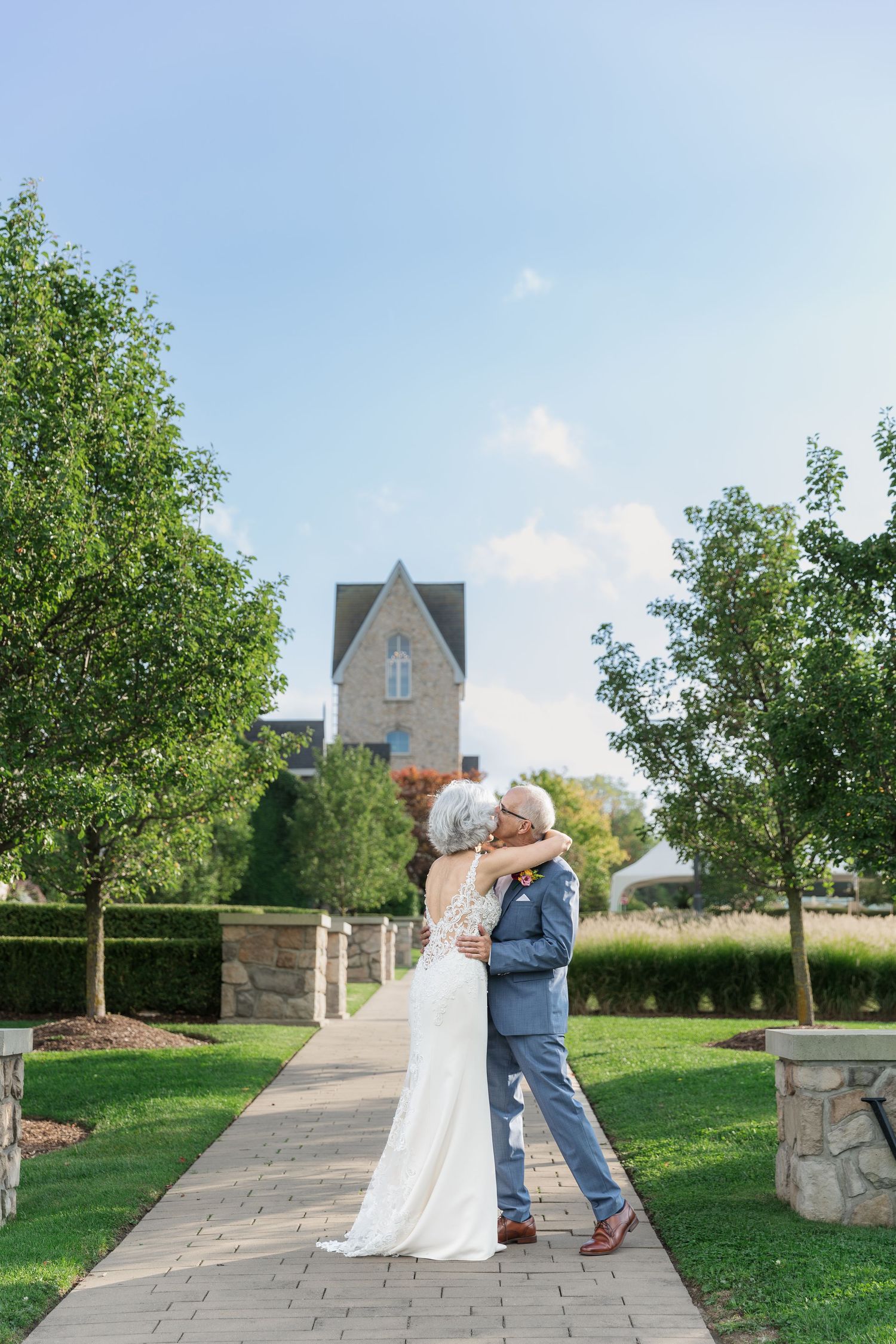 Bride and groom embrace romantically during their first look at Vineland Estates Winery.