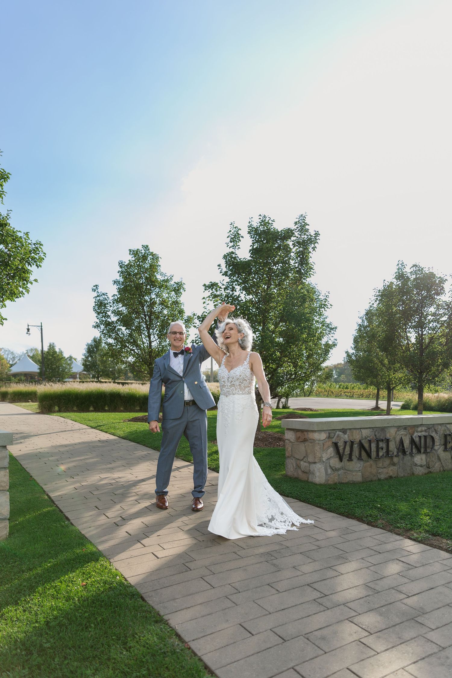Bride and groom enjoy a little twirl during their first look at Vineland Estates Winery.