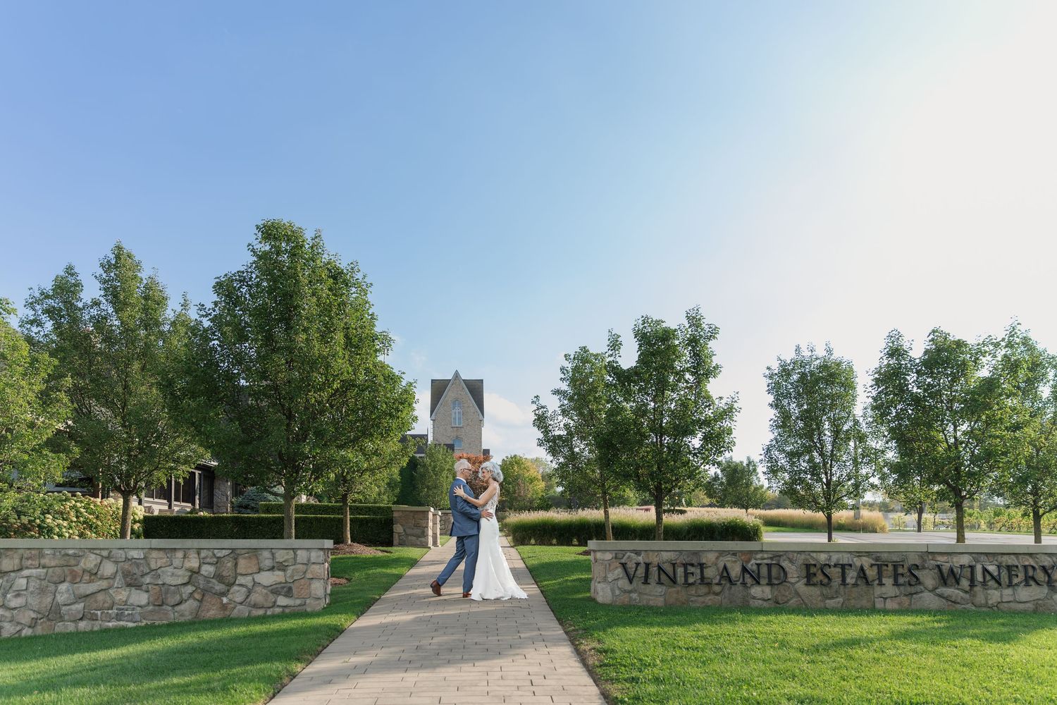 Bride and groom share an embrace on the grounds of the Vineland Estates Winery.
