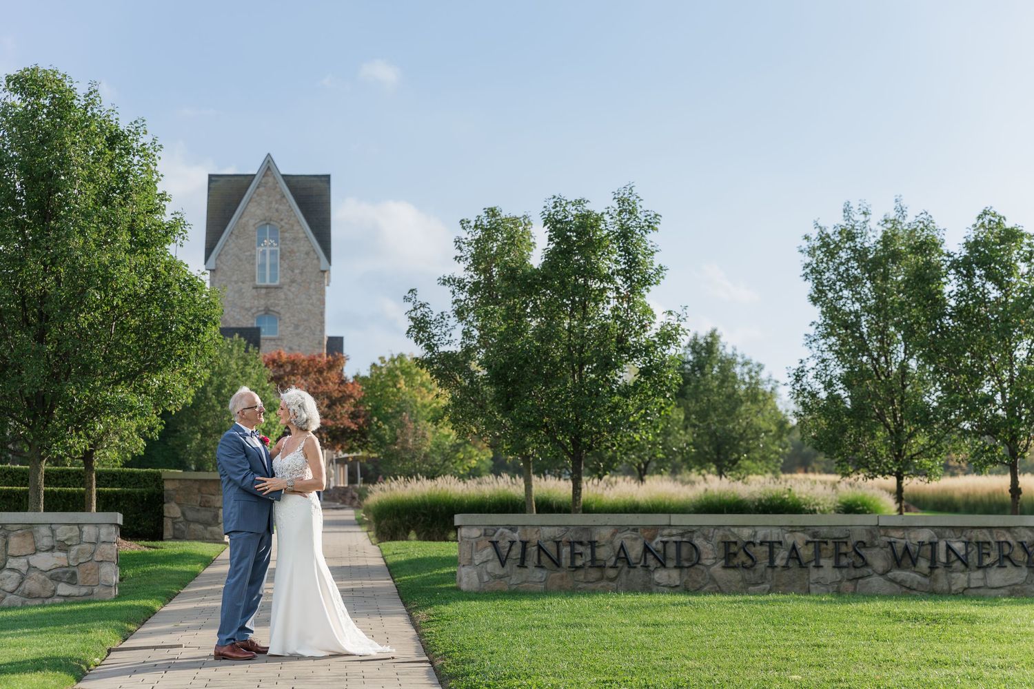 Winery estate grounds with stone paths and architectural features on sunny afternoon with a bride and groom at Vineland Estates Winery.