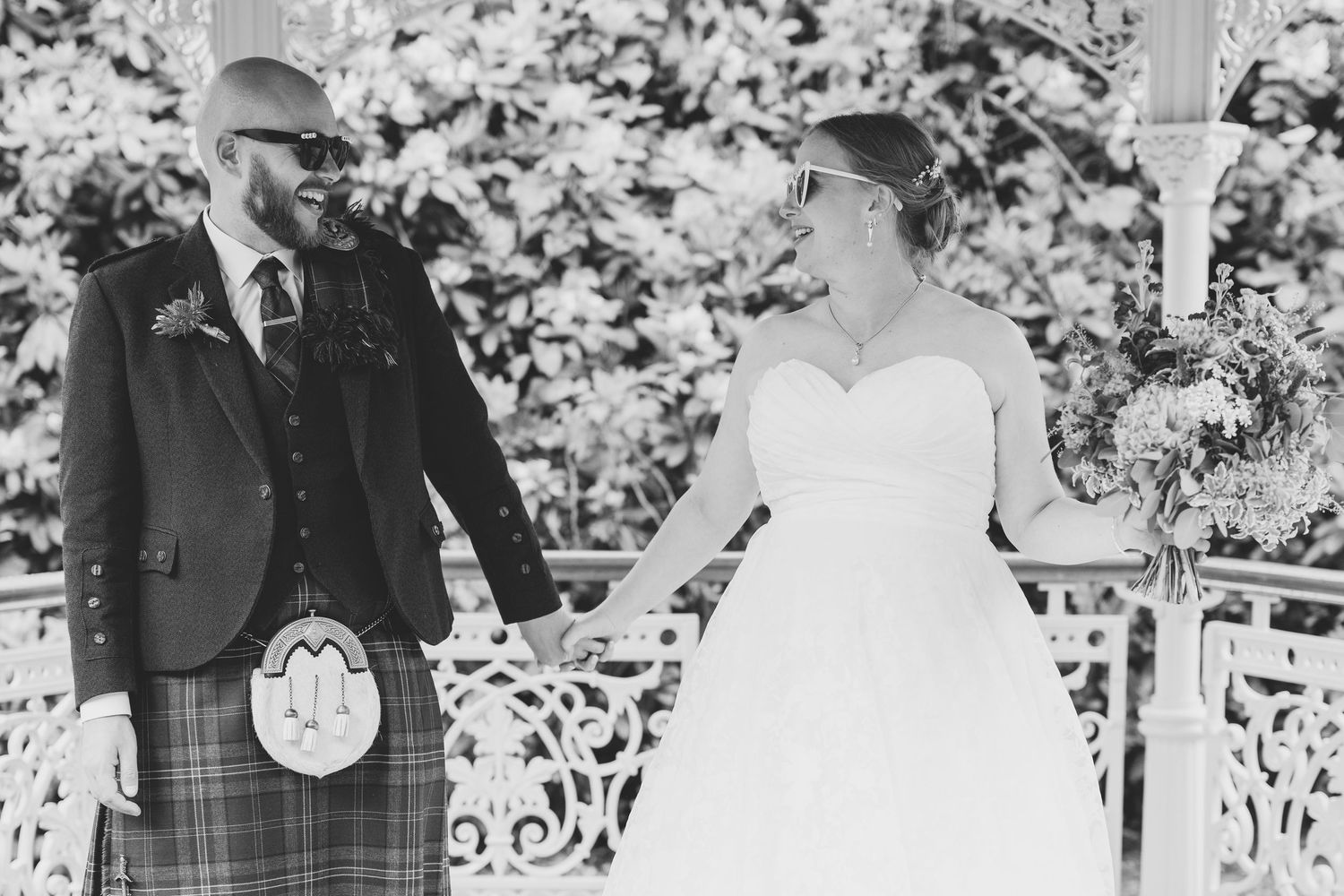 Black and white wedding portraits captured in an elegant garden setting.