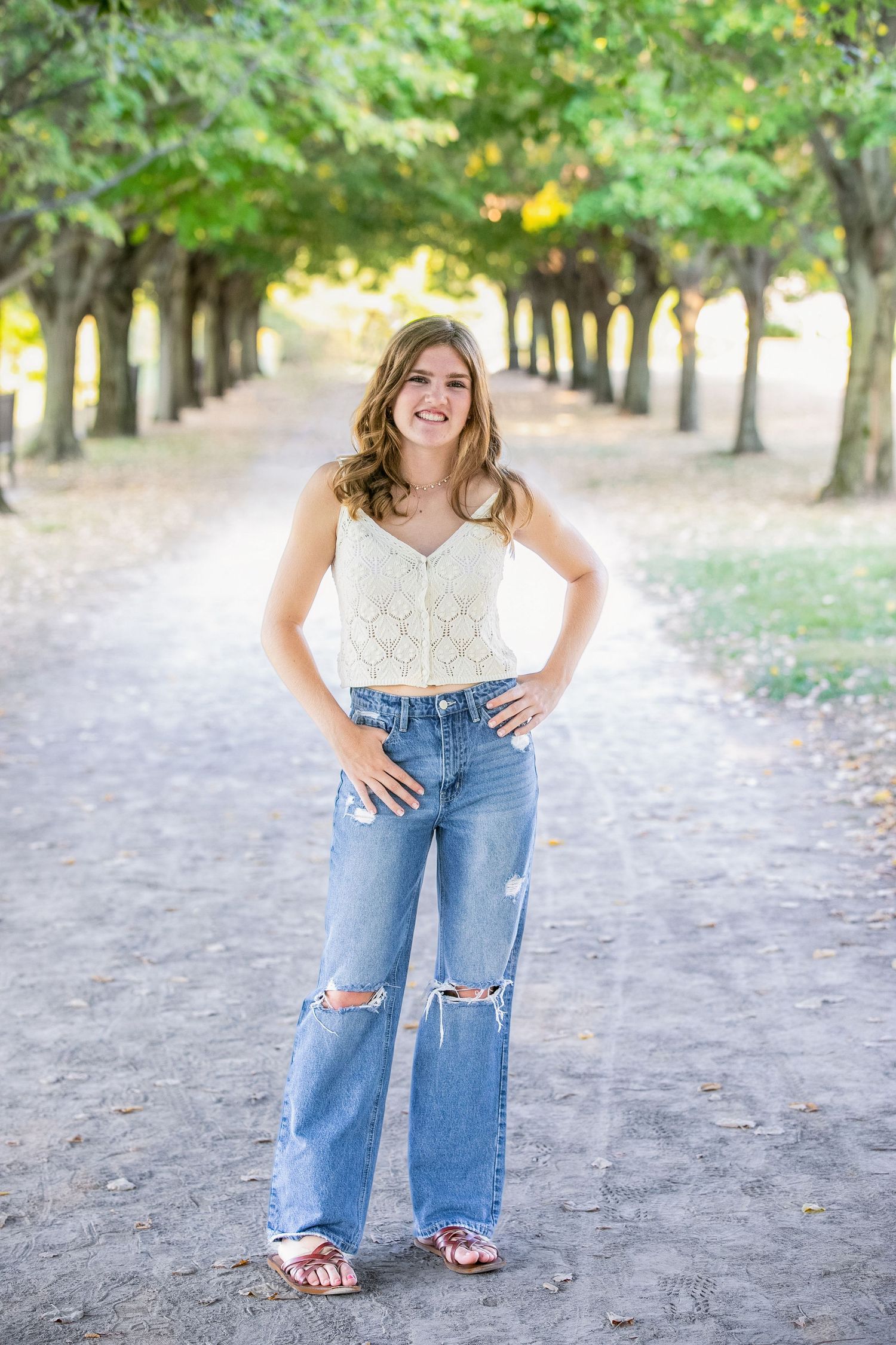 A series of outdoor portraits in a tree-lined path showing casual poses in ripped blue jeans and white top.