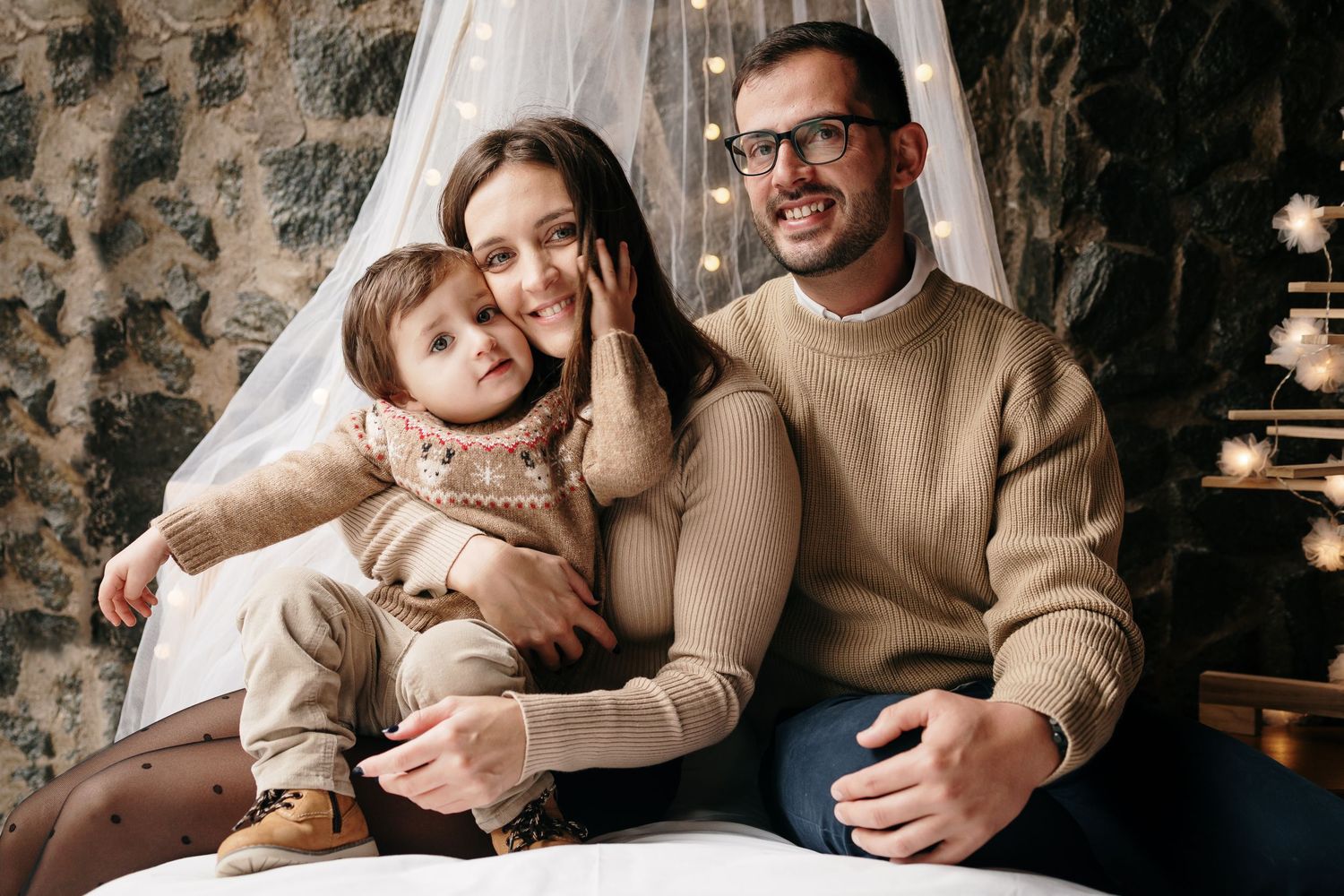 Family relaxes together on couch during intimate holiday photo session.