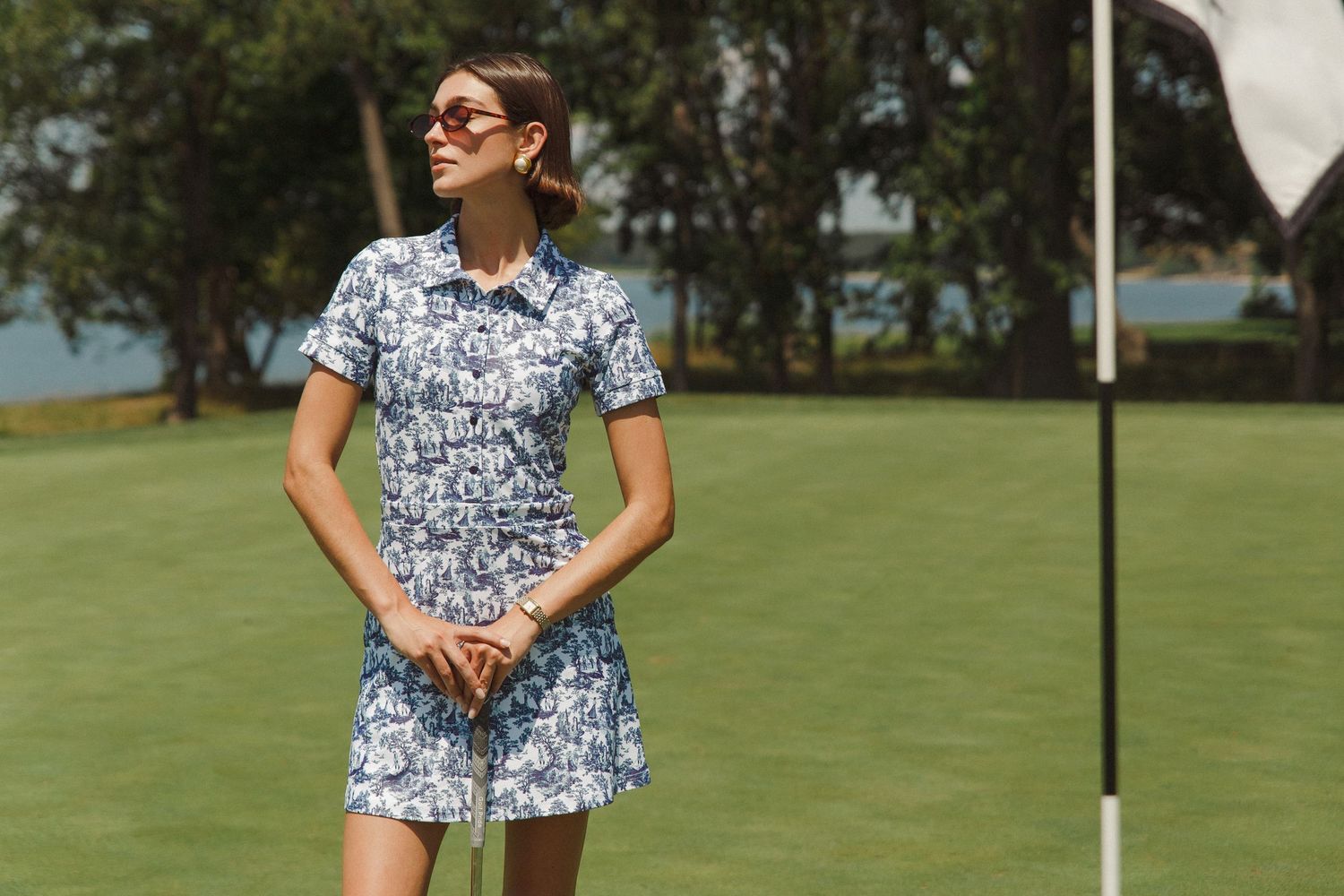 Model Haylee Michalski wears sunglasses on golf course at Queenstown Harbor Golf Resort, golf fashion photography for Smith & Quinn