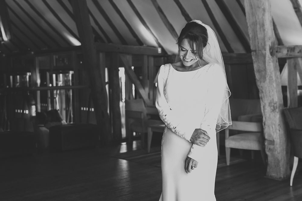 A candid moment of a bride dancing alone in a rustic barn venue.
