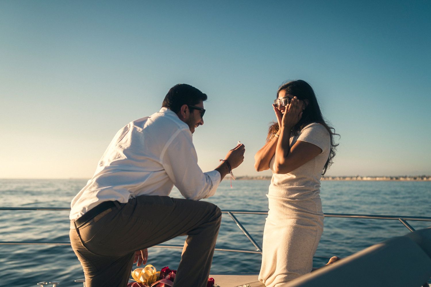 Two people enjoy a peaceful sunset boat ride on calm waters while fishing together.