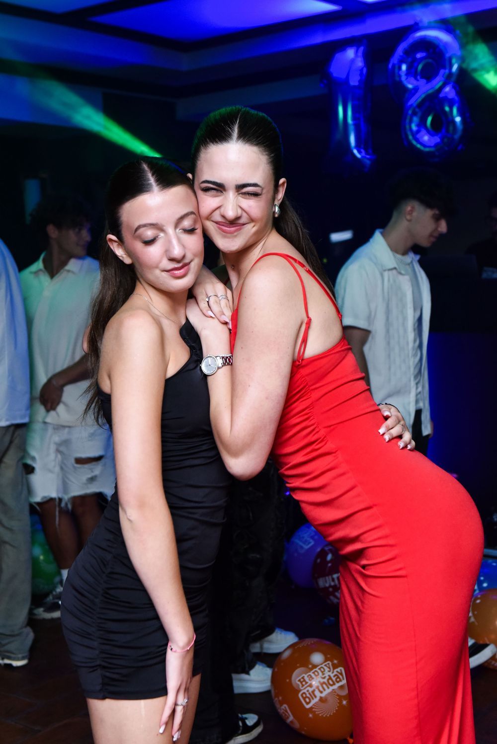 Two people dancing together at a nightclub with blue lighting and atmosphere.