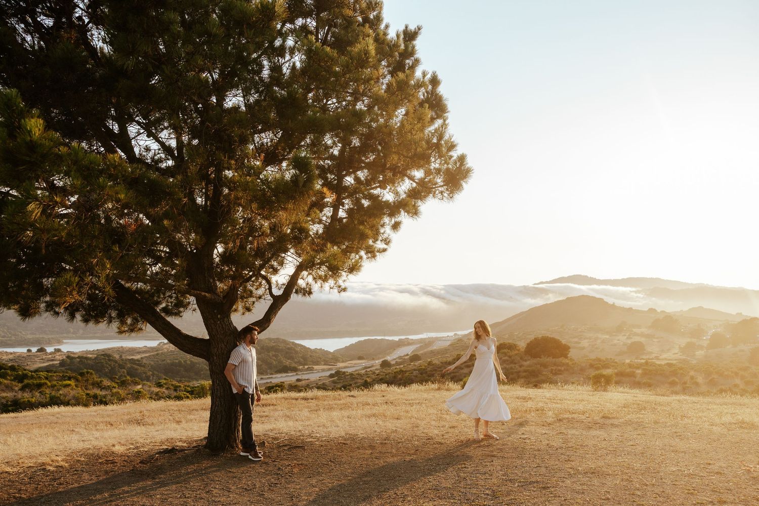 Bay Area engagement photoshoot at golden hour on a field overlooking a gorgeous view.