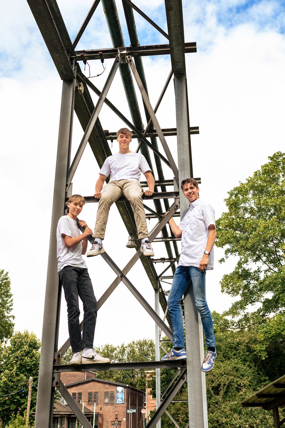 Freerunners klimmen in hoge masten op een industrieel terrein tijdens een fotoshoot