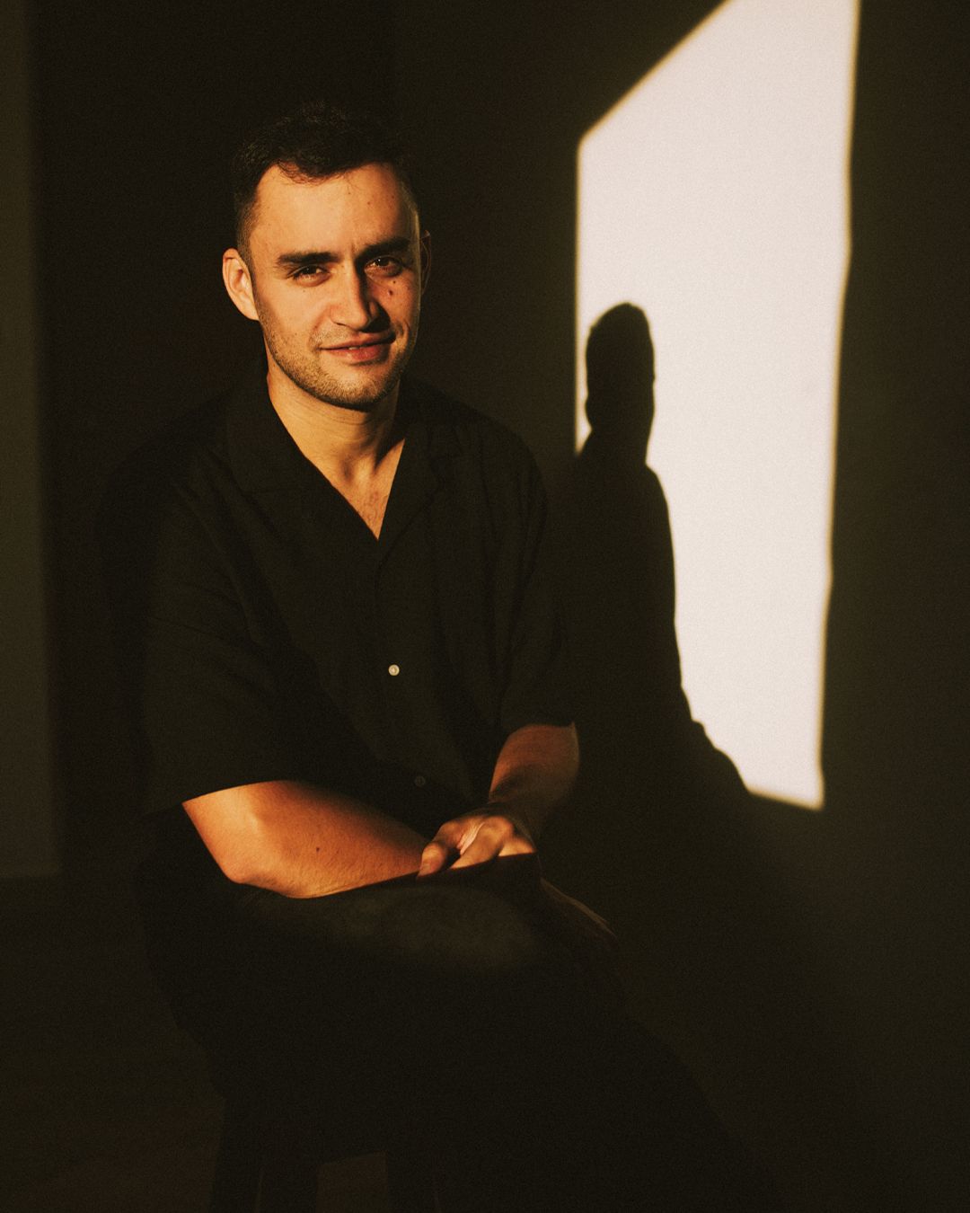 Dramatic black and white portrait series showing a person in dark lighting against a contrasting background.