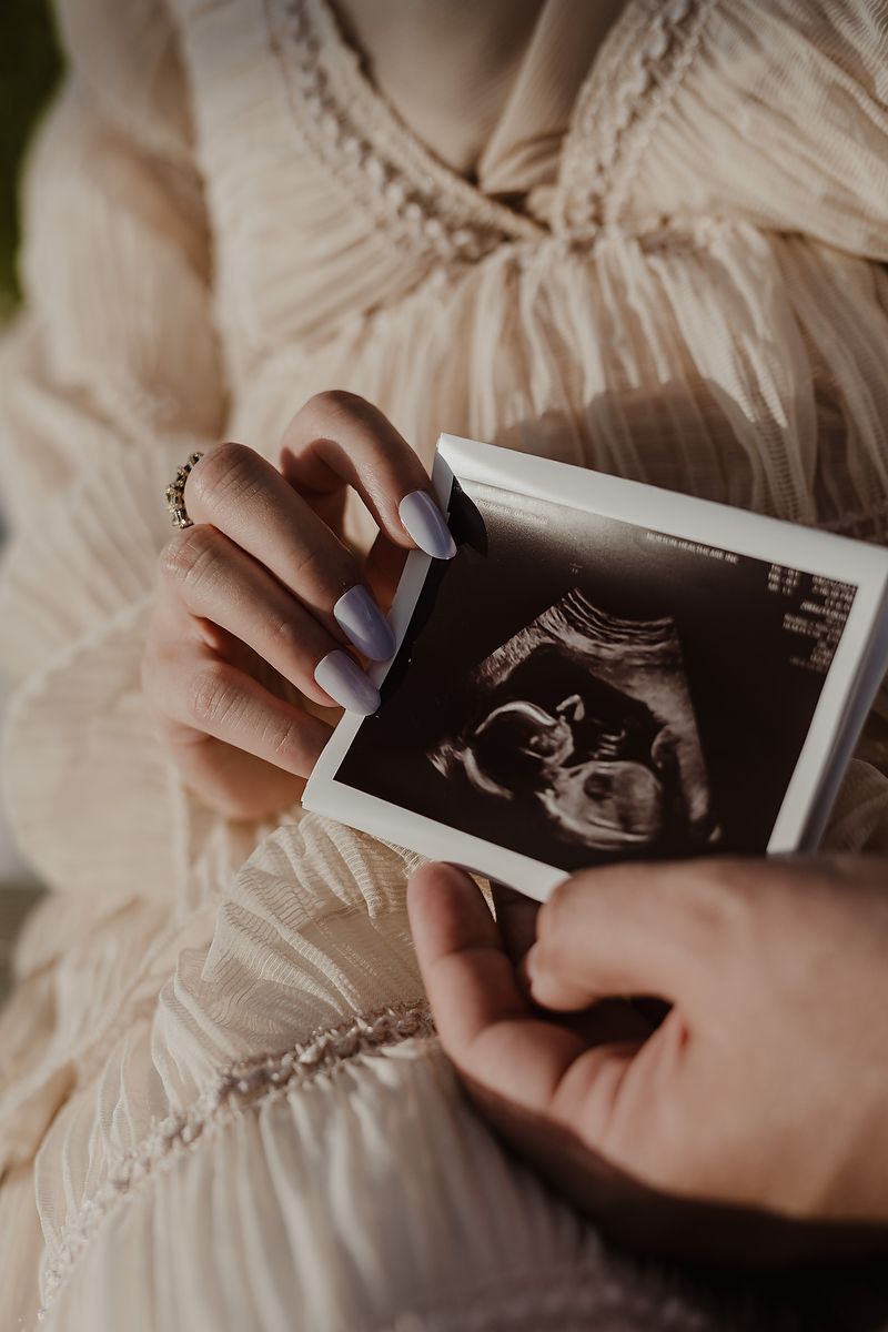 Pregnancy photo holding ultrasound at St. Regis Kanai Riviera Maya.