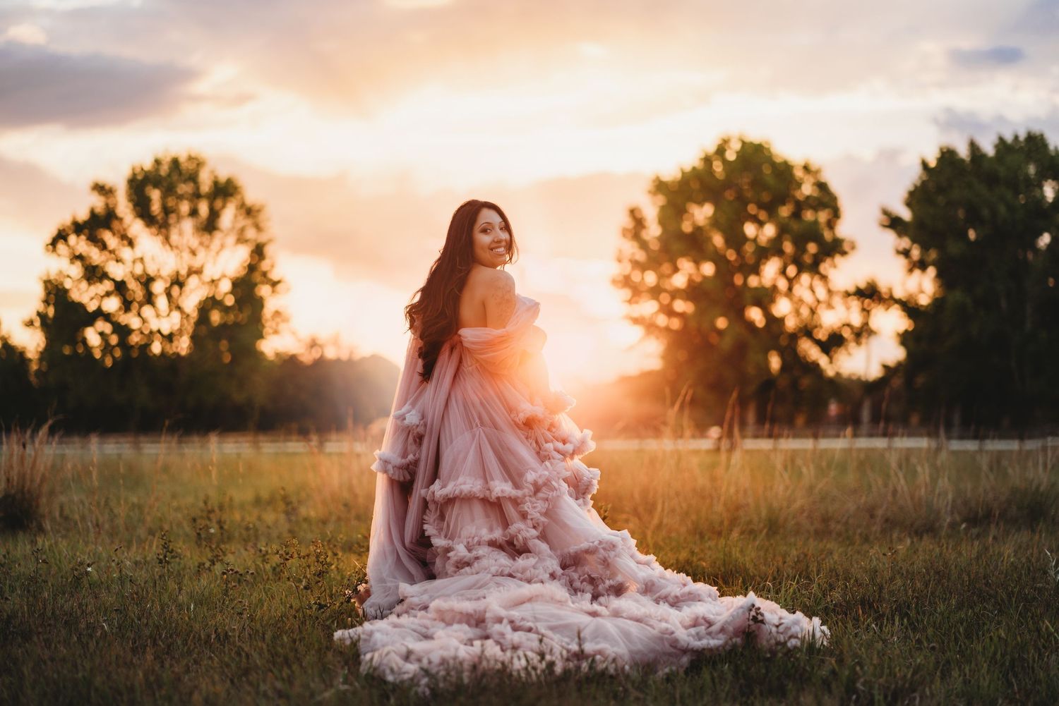 Black and white romantic moment captured between couple in a field with natural grass setting in soft focus.