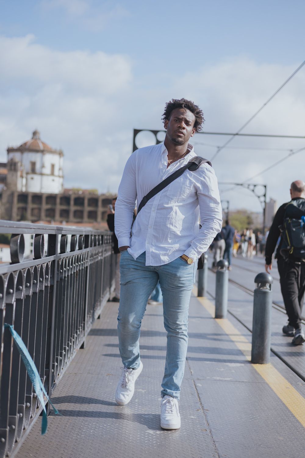 Street fashion photos on bridge wearing white shirt and light denim.