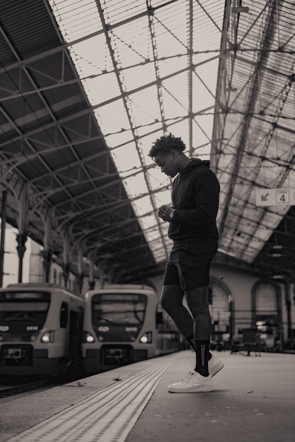 Atmospheric black and white photos taken at a train station platform.