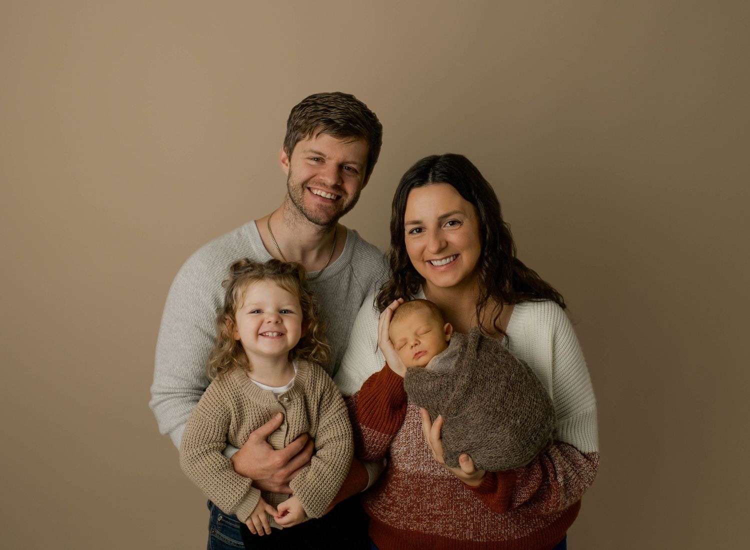 A series of candid family portraits showing joyful moments and laughter against a neutral beige backdrop.