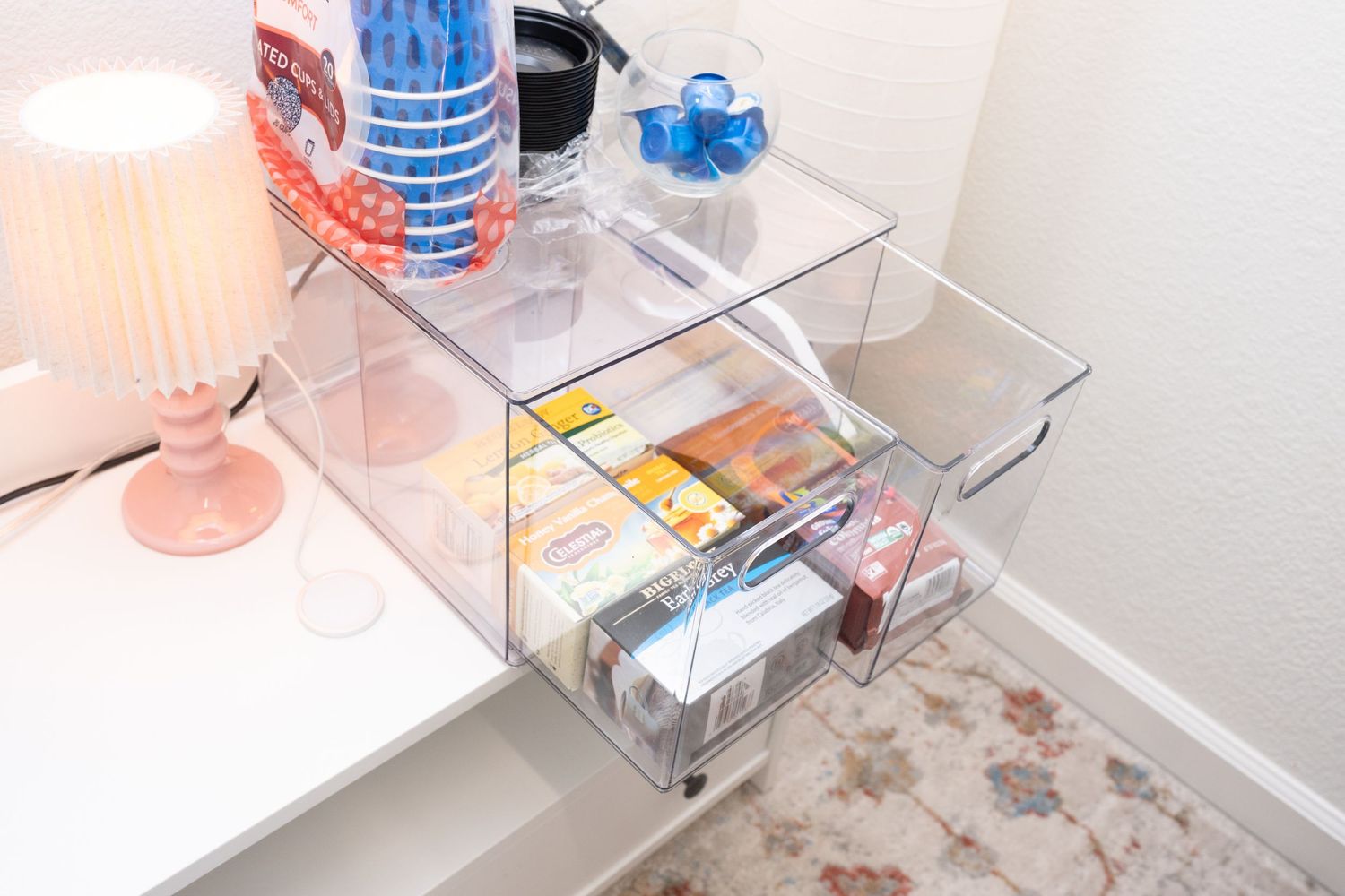 Clear storage drawer unit containing various household supplies and items.
