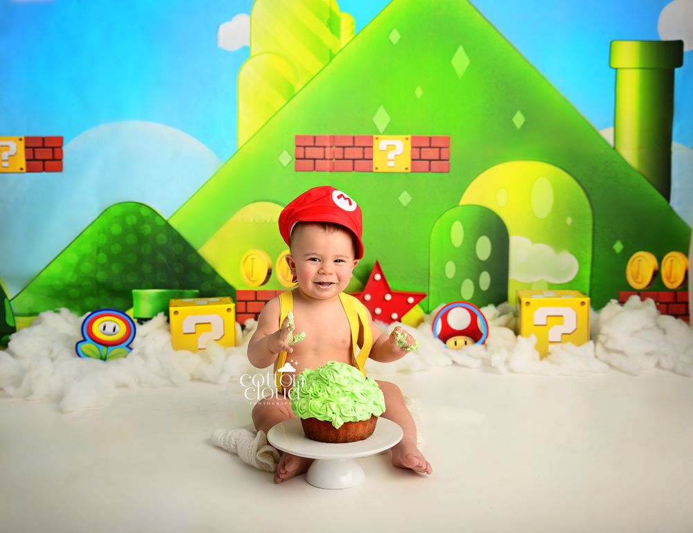 first birthday cake smash with Super Mario Bros themed backdrop and decorations. Campbelltown cake smash photographer