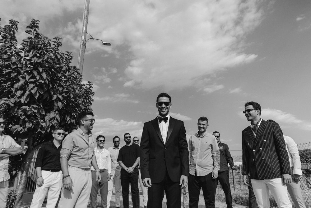 Black and white photo of wedding party members standing together outside.