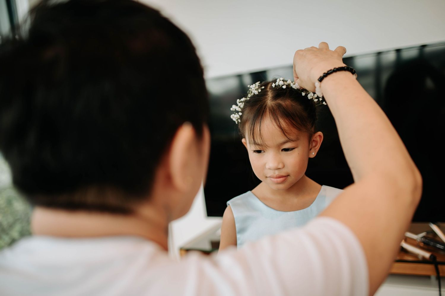 A young child getting ready with hair styling for a special occasion.