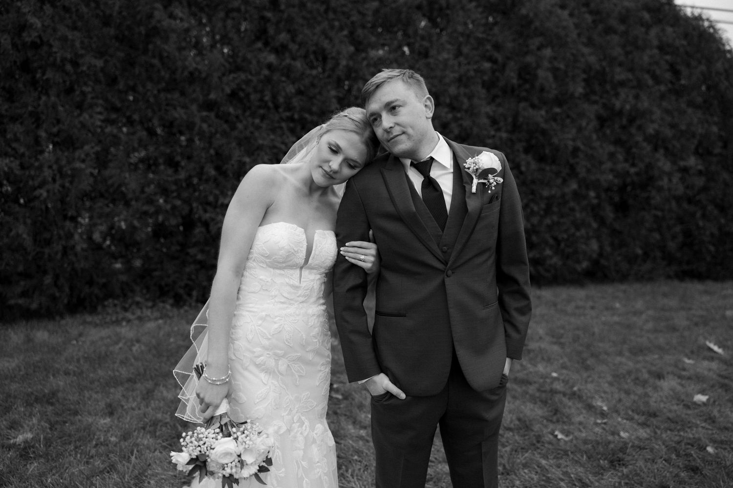 Black and white intimate wedding portrait with couple sharing tender moment.
