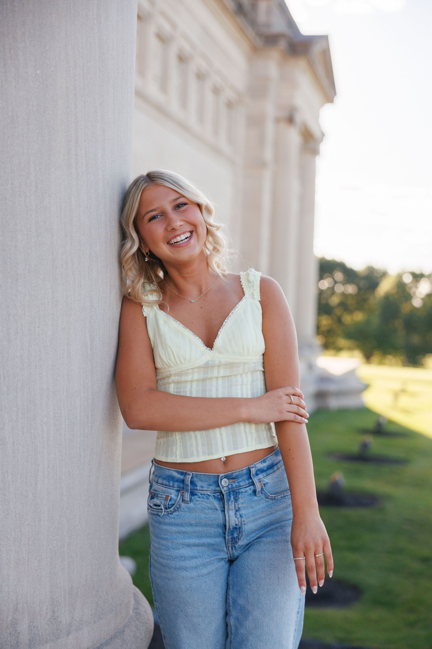 High school senior smiling during her St. Louis senior portraits at the Botanical Gardens. Authentic senior photography by Faith’s Flicks.