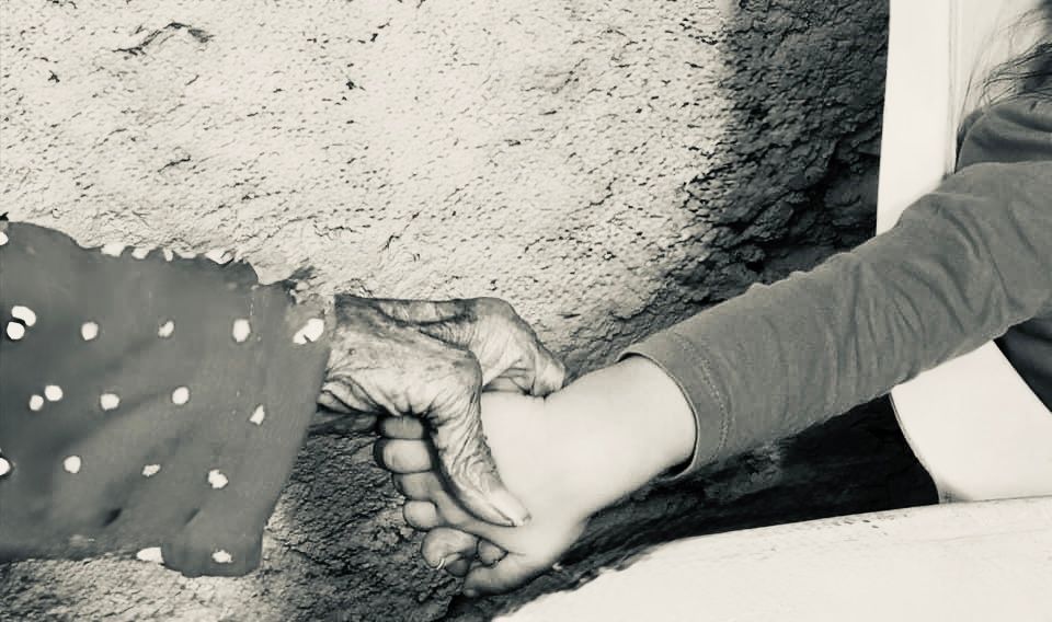 Close up of hands touching in black and white photograph.