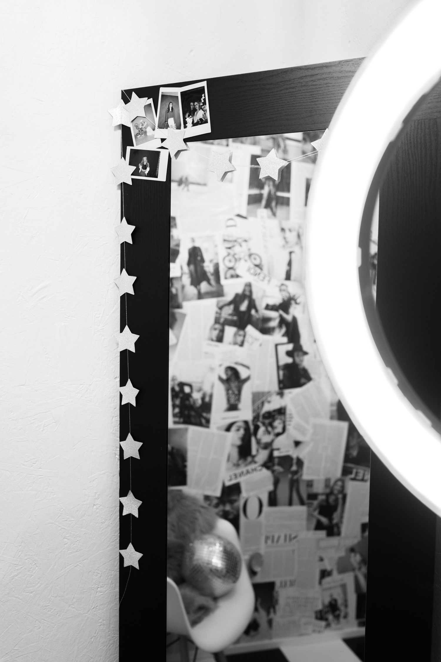 Black and white wall display with circular lighting fixture and decorative star accents.