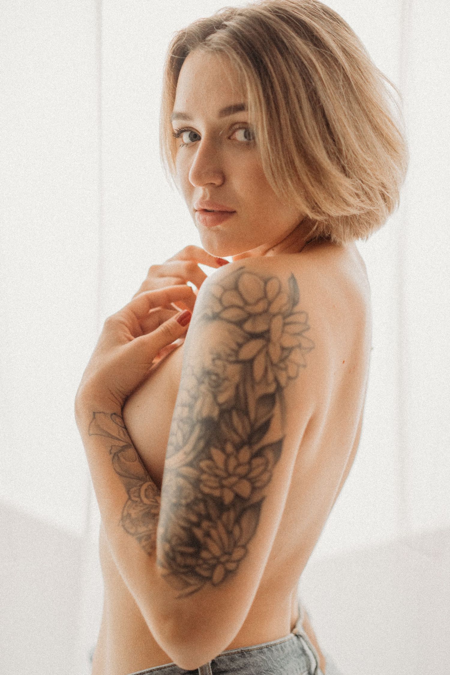 Studio portrait with bare torso: a woman lit by professional studio lighting.