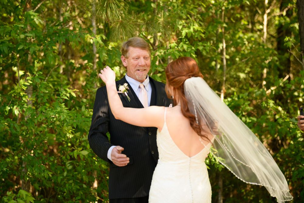 Romantic first look moment between couple during outdoor wedding ceremony.