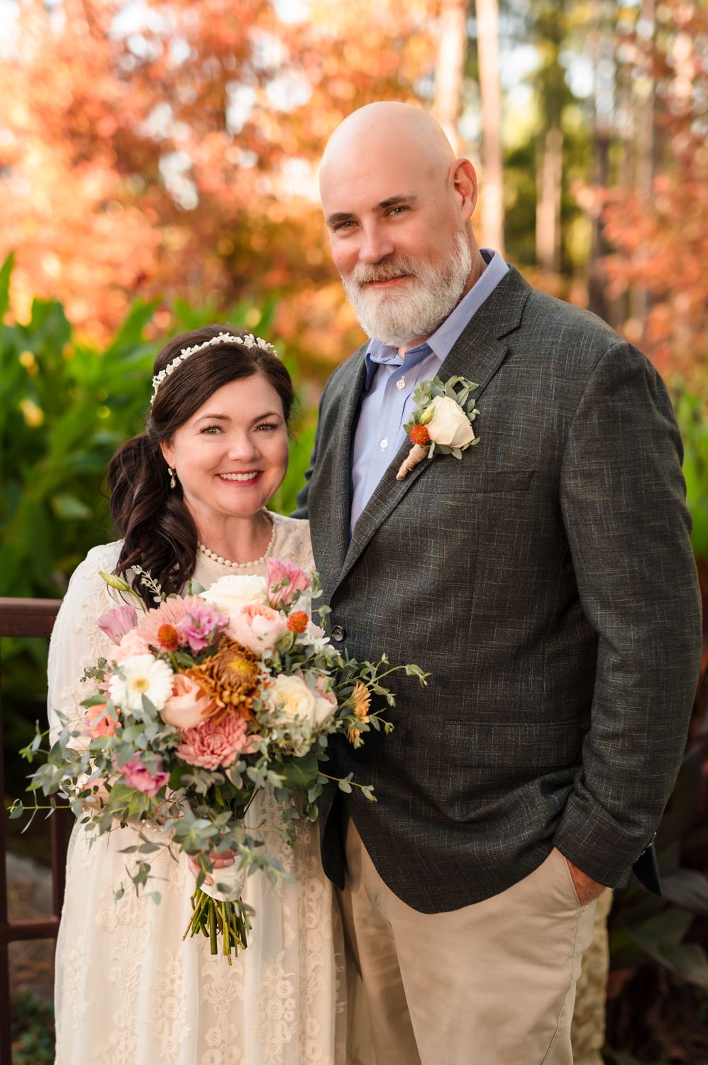 Autumn wedding portrait with elegant bouquet of pink and peach flowers.