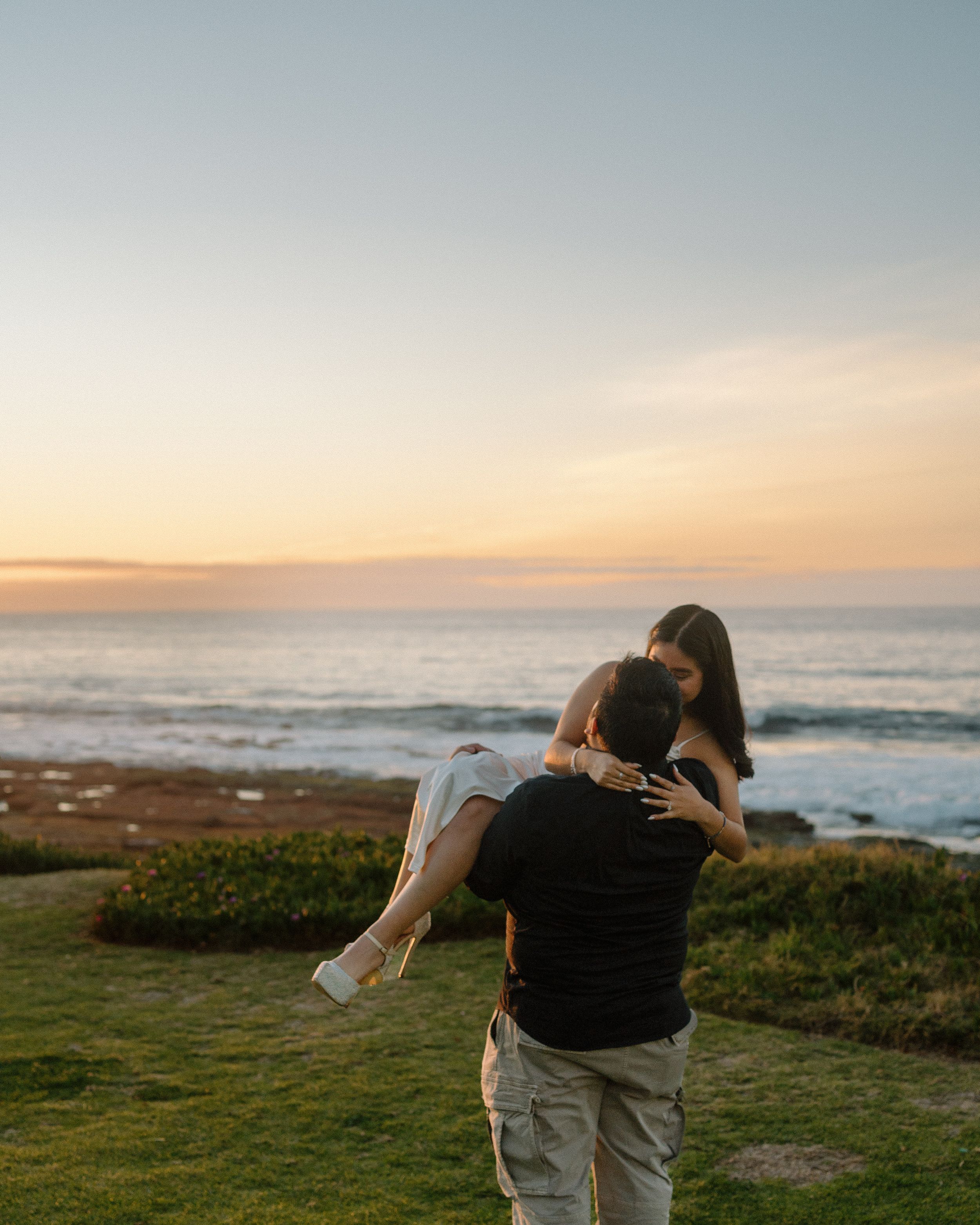Romantic oceanfront engagement session in San Diego. Golden hour photography capturing love, joy, and playful moments by the coast