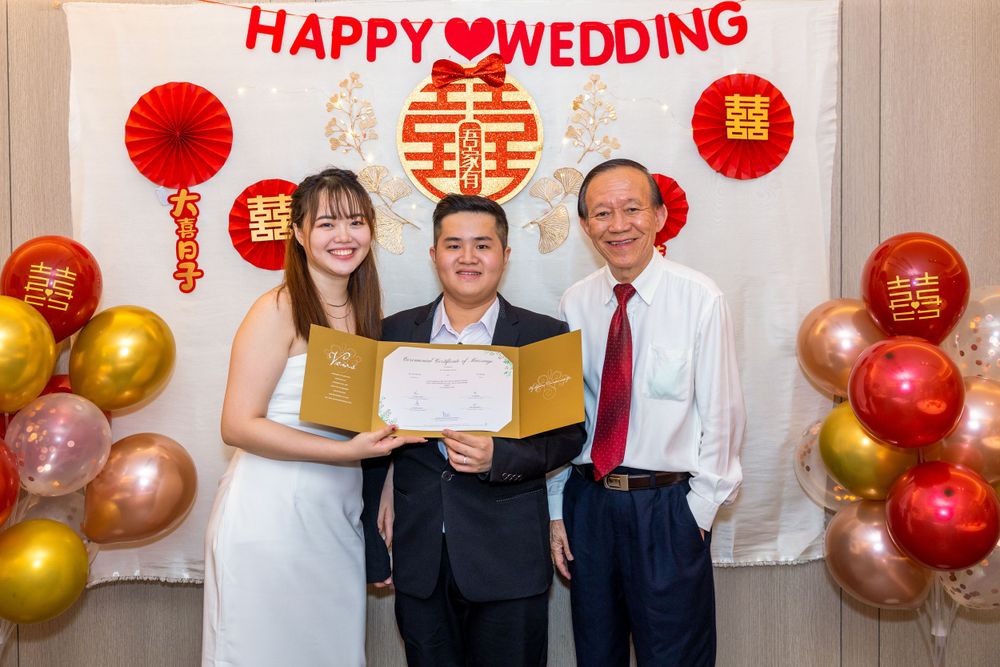 Wedding ceremony with traditional Chinese decorations featuring red paper fans and gold balloons.