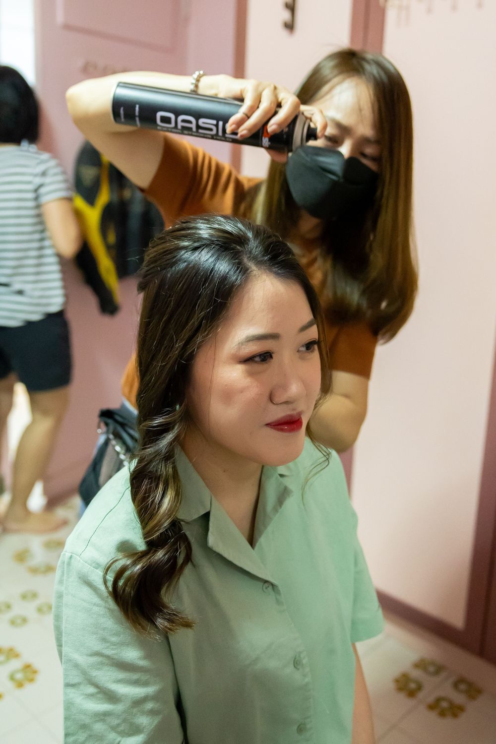 Hair stylist using professional tools to style client's hair in a salon setting.