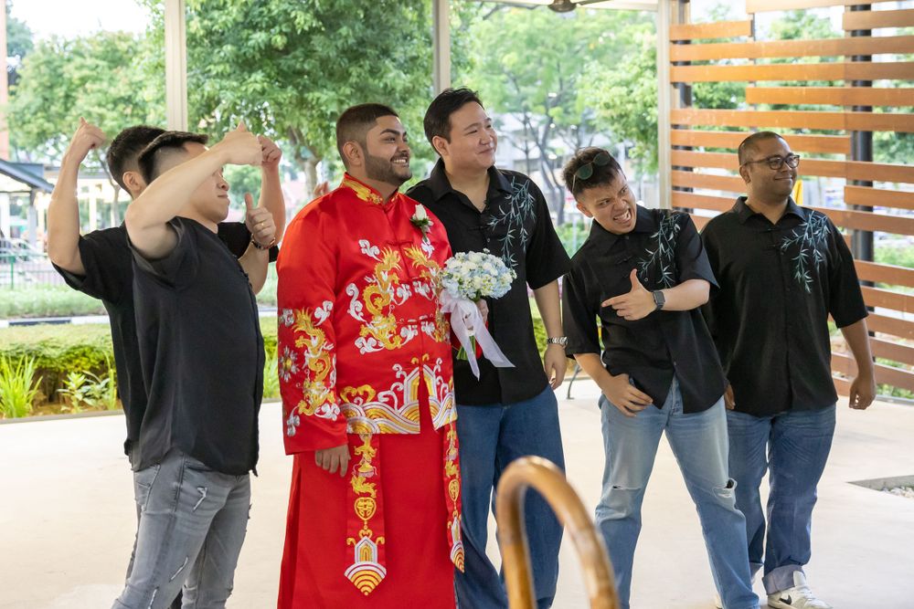 Group standing together outdoors with one person wearing traditional red Chinese wedding attire.