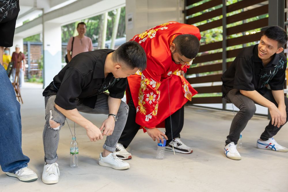 Group wearing casual clothes and traditional red attire gathering outdoors near a building.